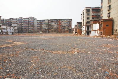 為降塵，旮旯王村拆遷后裸露的地面上鋪了一層石子。