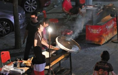 7月4日，青年路國(guó)美第一城小區(qū)附近的夜市臨街露天燒烤攤。