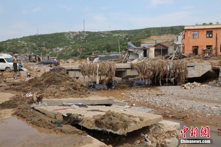 圖為洪水過后，坍塌的橋梁上遺落大量雜草。