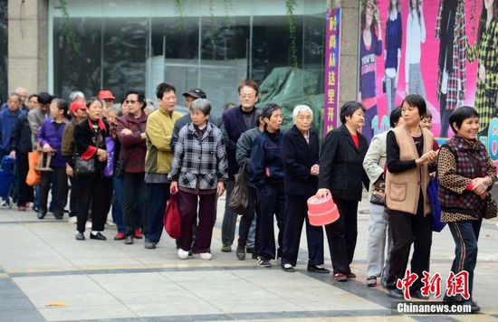 圖為10月28日，在江西九江市一家羊絨皮草服裝服飾博覽會(huì)現(xiàn)場(chǎng)，老人們正在頂著寒風(fēng)排隊(duì)等待領(lǐng)取10元代金劵。